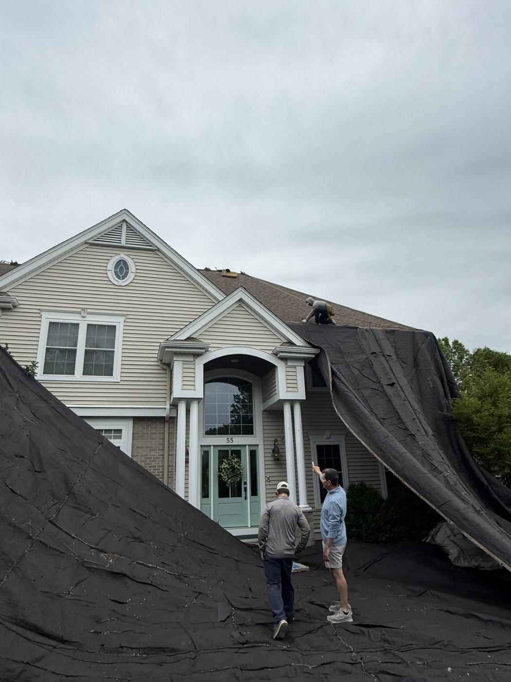 Rocco's Roofing crew replacing a roof on a colonial home
